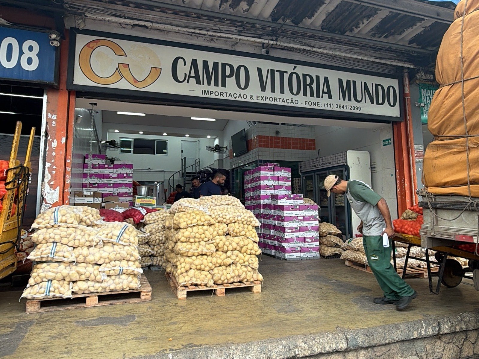 Box da Campo Vitória Mundo na CEAGESP, com pallets de alho e cebola sendo carregados